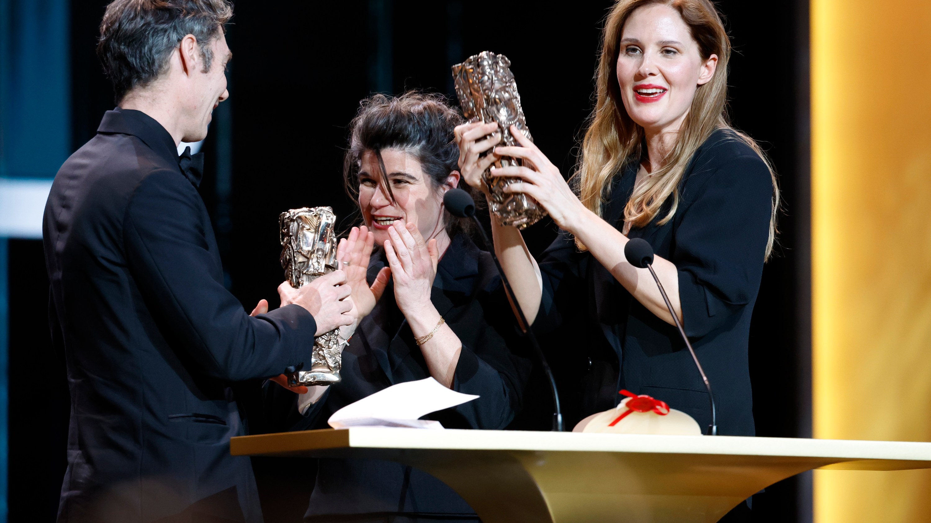 PARIS, FRANCE - 23 FÉVRIER : David Thion, Marie-Ange Luciani et Justine Triet acceptent le César du meilleur film sur scène lors de la 49e cérémonie des César du cinéma à l'Olympia en février. 