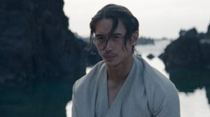 Un homme en robe blanche devant l'eau ;  toujours du film 